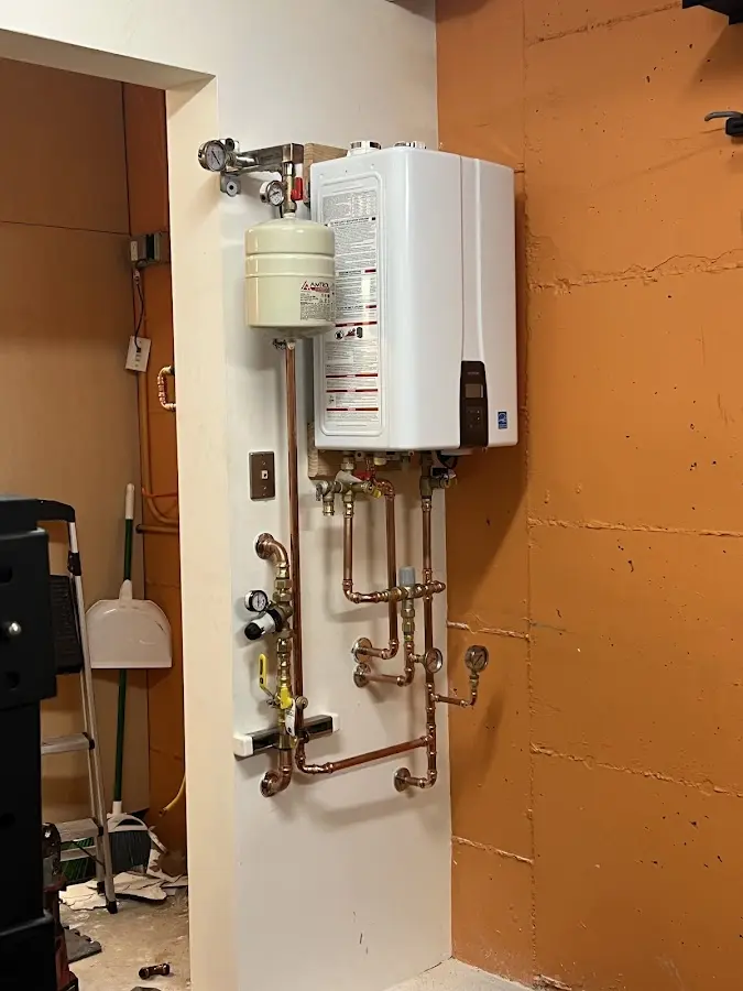 Plumbing technician inspecting water heater connections in Hattiesburg